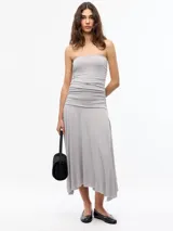Vestido midi strapless color gris, con frunces laterales en el torso y bajo con ruedo irregular.