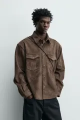 Sobrecamisa de corte regular fit confeccionada en tejido con efecto ante. Presenta cuello solapa, cierre frontal con botones a presión, mangas largas con puños abotonados y dos bolsillos de plastrón con solapa en el pecho.