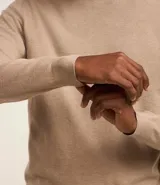 Suéter de punto color borgoña, con cuello redondo, sisas ligeramente desplazadas y bajo y puños acanalados.