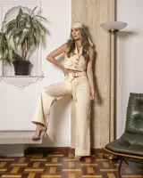 Chaleco beige con cuello solapa, sin mangas, con botones frontales y bolsillos de parche.