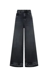 Jean wide leg negro de tiro alto con perneras anchas y dobladillo deshilachado, con bolsillos delanteros y traseros, y cierre frontal con botón metálico y cremallera.