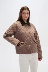 Campera marrón con diseño acolchado, cuello de pana marrón, cierre con botones a presión y bolsillos laterales.