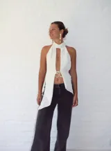 Top blanco con textura, cuello halter y abertura en el frente.