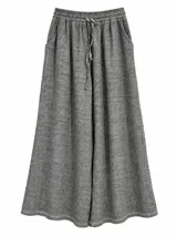 Pantalón ancho color gris, de corte fluido, cintura elástica con cordón de ajuste y bolsillos laterales.