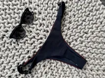 Bottom de bikini colaless, color negro en la parte trasera y bordeaux en la parte delantera. Confeccionado en lycra premium, sin costuras y con breteles regulables en los costados.