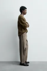 Jersey de punto de lana con corte regular fit, cuello redondo y manga larga. Presenta un diseño minimalista con acabados enrollados en cuello, puños y ruedo.