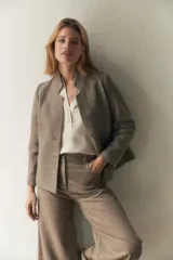 Chaqueta corta color marrón con cuello solapa, manga larga con coderas aplicadas, cierre frontal con botones y bolsillos ojal. Con forro. Tela 100% lana fina sin teñir, diseñada exclusivamente por Don Baez. Hecha 100% en Uruguay.