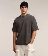 Remera de corte boxy y diseño liso, confeccionada en algodón con efecto desteñido, cuello redondo alto y mangas cortas.