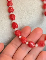 Collar de diseño artesanal compuesto por cuentas de coral en tono rojo e intercaladas con pequeños cristales facetados en color rosado claro.
