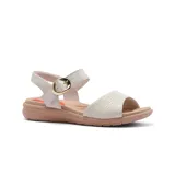 Sandalias bajas de cuero color blanco hueso, con tira ancha sobre el empeine y tira con hebilla dorada al tobillo. Suela color beige.