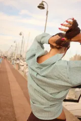 Camisa de corte clásico con estampado de rayas verticales en color celeste y blanco, cuello camisero y cierre frontal con botones.