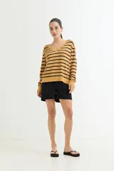 Sweater de tejido de punto, manga larga, con escote en V y patrón de rayas horizontales anchas en blanco y negro.