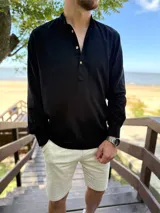 Camisola de lino negra de manga larga, con cuello mao y cierre frontal parcial de botones.