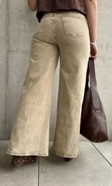 Pantalón de jean color beige con efecto óxido, de tiro alto y corte ancho en las piernas.