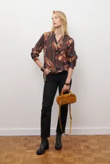 Camisa de manga larga con estampado floral en tonos marrones y negros, cuello mao y cierre frontal parcial con botones.