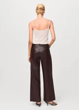 Pantalón de corte recto y tiro medio con efecto piel, diseño largo, trabillas en la cintura y cierre frontal de cremallera y botón, con cinco bolsillos.