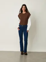 Jean de corte bootcut color azul oscuro, con tiro medio, bolsillos clásicos y cierre frontal con botón y cremallera.