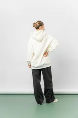 Campera deportiva con capucha de corte oversize, confeccionada en tejido suave con interior forrado en piel sintética. Presenta cierre frontal completo, bolsillos laterales y capucha amplia con cordones largos ajustables.