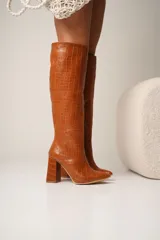 Botas altas de cuero vegano con estampado de cocodrilo, taco cuadrado y punta fina. Disponibles en color negro y marrón. La caña mide 40cm y el taco 8cm.