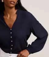 Camisa azul marino de viscosa con cuello mao, cierre frontal con botones y mangas largas con puños elásticos.