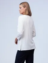 Blusa blanca de tejido elastizado marca Ruby Rd. Tiene escote redondo con aplique metálico y mangas 3/4.