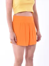 Short de tela liviana con textura plisada, color naranja, con cintura elástica alta tipo nido de abeja.