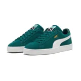 Championes Puma modelo Suede Classic, confeccionados en gamuza de color negro con la icónica franja lateral en blanco y el logotipo de la marca impreso en dorado metalizado en el lateral. Suela de goma texturizada en color blanco.