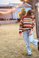 Sweater de lana con rayas horizontales en tonos rojo, ocre, marrón y blanco.