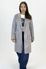 Chaqueta de corte recto en color gris, confeccionada en material tipo gamuza sintética. Presenta solapas clásicas, cierre frontal, mangas largas y dos bolsillos frontales aplicados.