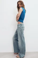 Jeans de denim de tiro medio y corte relaxed con diseño de cinco bolsillos, trabillas en la cintura y cierre frontal con cremallera y botón metálico.