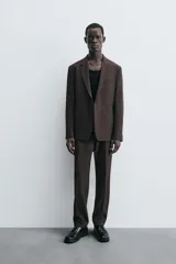 Blazer de corte regular fit confeccionado en tejido con lana. Presenta cuello con solapas de muesca, cierre frontal de un botón, bolsillos de vivo en el pecho y en la cadera, y aberturas en la espalda.