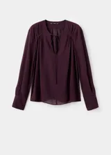 Blusa de viscosa color bordó, con escote en V y cierre de lazo, de manga larga con puños abotonados y diseño recto.