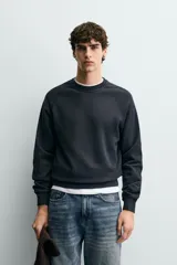 Sudadera regular fit color azul, de cuello redondo, manga larga ranglán y efecto lavado con acabados en rib.