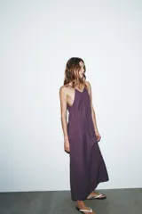 Vestido midi color lila de cuello halter y tirantes finos ajustables en la espalda.