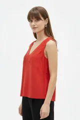 Musculosa de algodón color rojo, de bretel ancho, con escote en V y detalles de encaje aplicado alrededor del cuello.