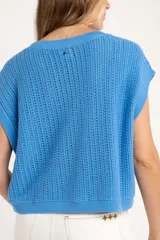 Chaleco sin mangas de tejido de punto color rosado pálido, con textura calada y acabado lurex, corte al cuerpo y cuello redondo.