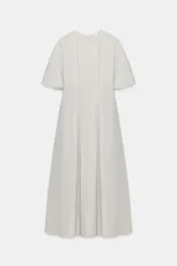 Vestido midi de popelín de algodón en color beige, con cuello redondo, manga corta y pliegues en la cintura. Presenta una falda en línea evasé y cierre en la espalda con cremallera oculta.