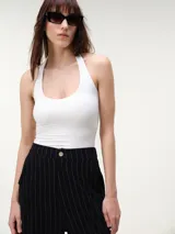 Top halter cropped de tejido rib color beige, con escote redondo pronunciado y espalda descubierta, de calce entallado.