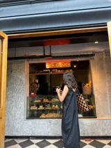 Bolso tipo tote de cuero trenzado a mano con diseño de damero en colores marrón y beige. Cuenta con doble asa trenzada y forro interior.