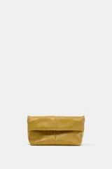 Bolso de mano tipo sobre color mostaza, con diseño acolchado y costuras geométricas. Cuenta con cierre imantado y asa tipo bandolera extraíble.