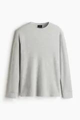 Remera de manga larga en punto waffle color gris, de corte ajustado y cuello redondo con ribete acanalado.