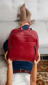 Mochila de cuero sintético color azul con diseño acolchado de rombos en el frente. Cuenta con bolsillo frontal con broche magnético, asa de mano superior y correas regulables. El compartimento principal incluye bolsillos internos con cierre y divisiones.