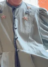 Chaqueta color celeste con bordados de motivos marinos, de corte recto, hombros levemente marcados y botones delicados teñidos al tono.