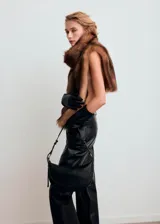Bolso tipo bandolera color negro, de diseño curvado, con asa ajustable y herrajes metálicos dorados.