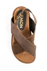 Sandalias de cuero color marrón con tiras cruzadas en el empeine, suela chunky texturizada y tira trasera ajustable con hebilla metálica.