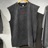 Musculosa de algodón color negro con lavado stone wash y efecto desgastado. Presenta cuello redondo, mangas con terminación rústica y el texto 'Become.' bordado en color rojo en la parte posterior.