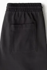 Pantalón jogger de algodón con corte relajado, cintura elástica con cordón ajustable, piernas rectas y bolsillos de parche delanteros.