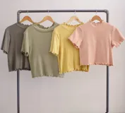 Remera de punto color verde claro, con cuello alto y mangas cortas con terminación ondulada.