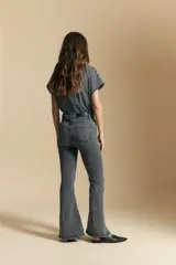 Jean oxford de tiro alto confeccionado en denim con spandex, de color gris oscuro lavado. Presenta un corte ajustado en la parte superior que se ensancha hacia el ruedo, el cual incluye aberturas frontales.