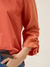 Remera de manga larga color blanco con cuello redondo y detalles fruncidos con lazos en las mangas.
